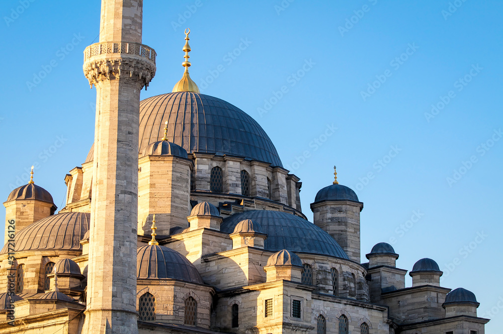 Golden sunset close up view of the dome and minaret of the Blue Mosque against blue sky in Istanbul, Turkey