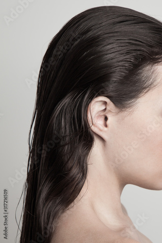 profile of young woman with long dark  wet hair natural beauty concept