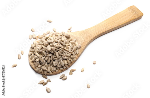 Peeled sunflower seeds with wooden spoon isolated on white background, top view