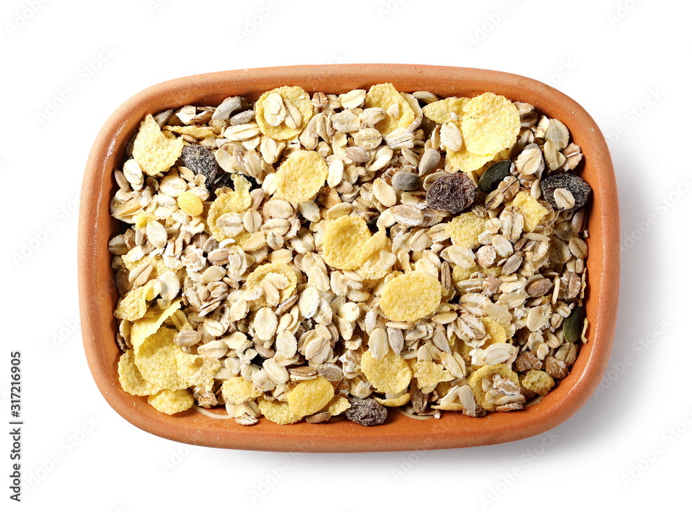 Muesli mixture of wholegrain foods, cereals, seeds and raisins in clay bowl isolated on white background, top view Muesli mixture of wholegrain foods, cereals, seeds and raisins in clay bowl isolated on white background, top view