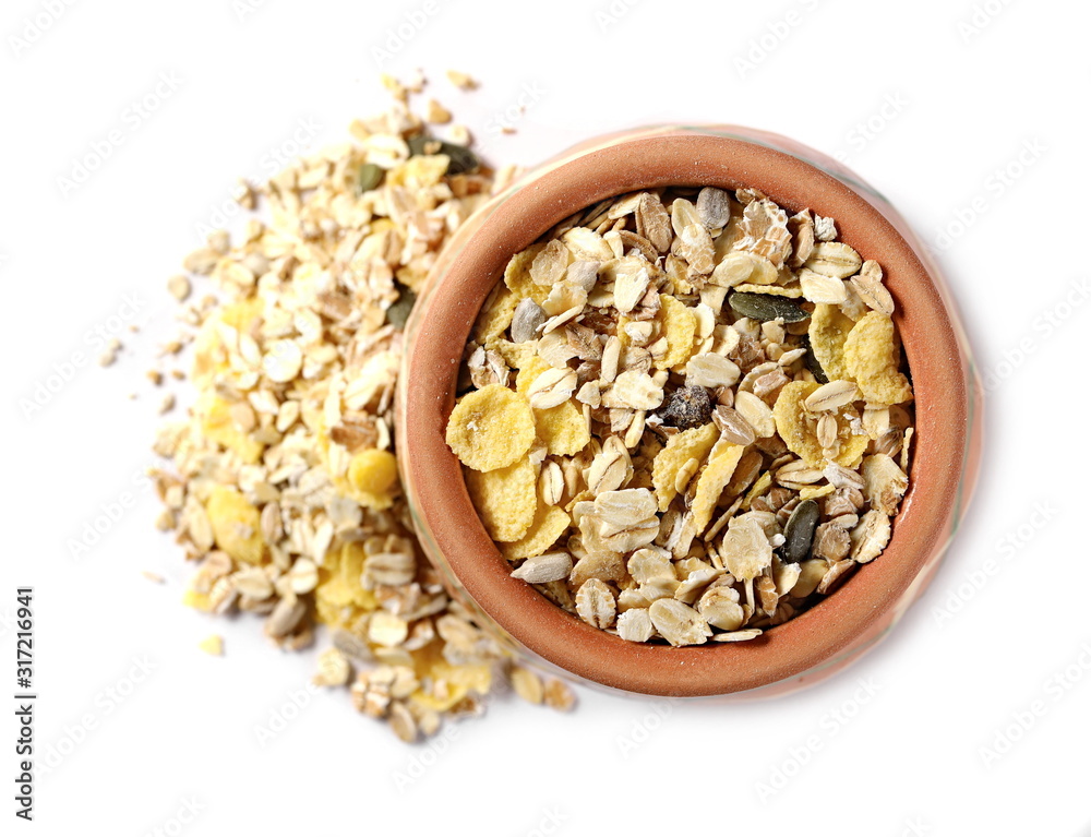 Muesli mixture of wholegrain foods, cereals, seeds and raisins in clay bowl isolated on white background, top view Muesli mixture of wholegrain foods, cereals, seeds and raisins in clay bowl isolated on white background, top view