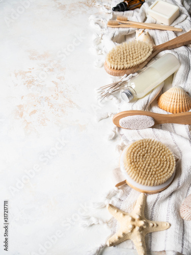 Different body brushes, pumice, cosmetics, bamboo toothbrush, cosmetics on white cotton towel. Copy space. Plastic free life. Zero waste concept. copy space