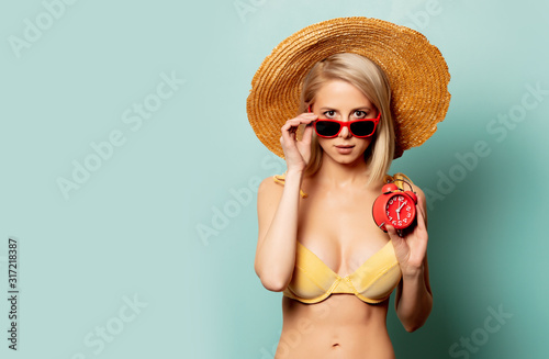 blonde woman in bikini with alarm clock