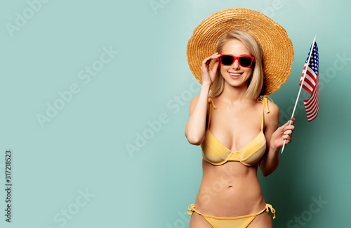 Beautiful blonde woman in bikini with flag of USA