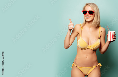 Beautiful blonde woman in bikini with paper cup © Masson