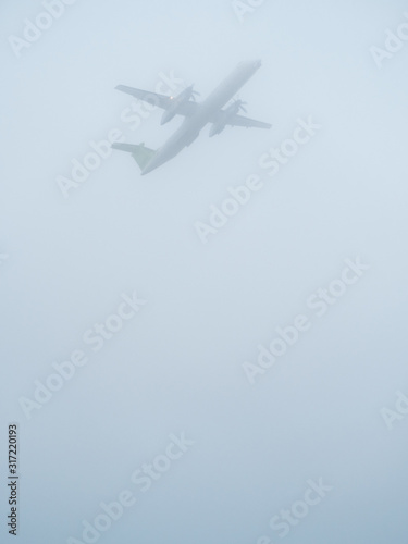 propeller airplane takes off in foggy weather