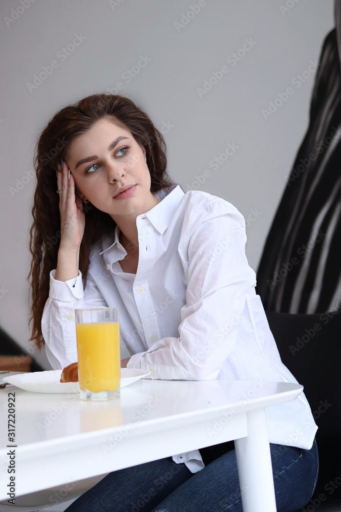 woman has breakfast at home with orange juice and croissant, lvertical photo woman has breakfast at home with orange juice and croissant, lvertical photo