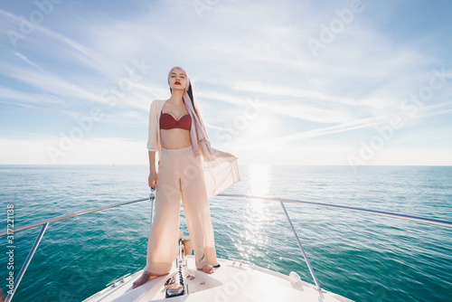a girl with glasses at the stern of the boat stands in the rays of heaven and looks into the distance © nelen.ru