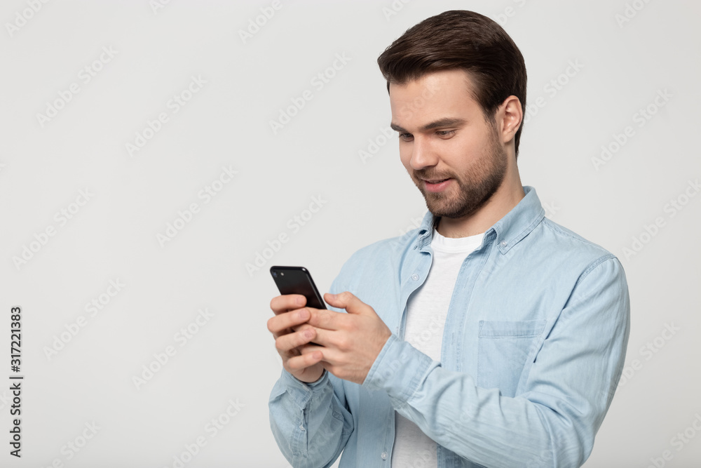 Half side head shot young happy man holding phone. Half side head shot young happy man holding phone.