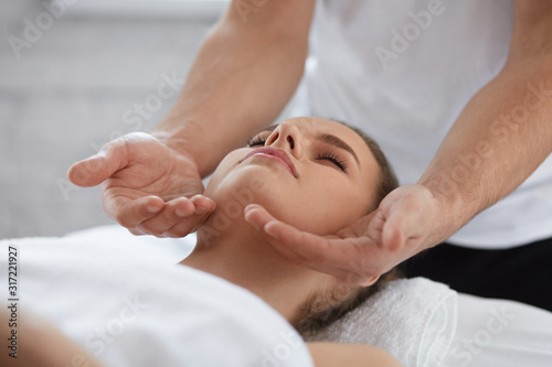Foto Young beautiful woman enjoying anti-aging facial massage