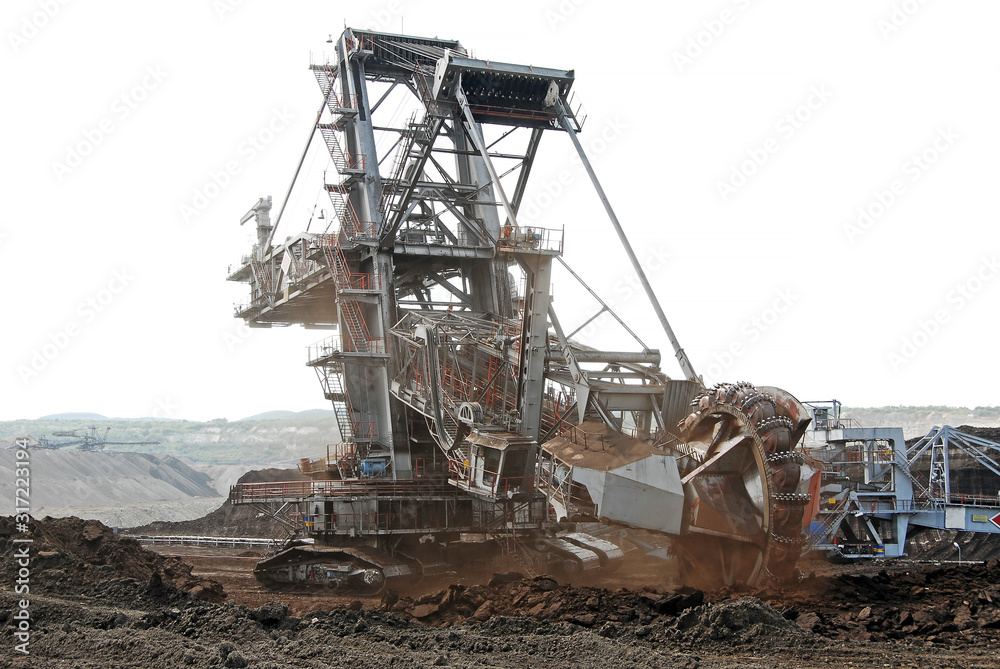 A huge bucket-wheel excavator digging coal on the open-pit mine. A huge bucket-wheel excavator digging coal on the open-pit mine.