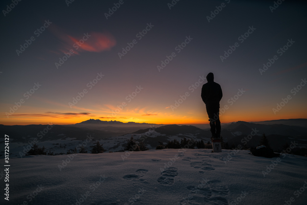 silhouette of man on top of mountain