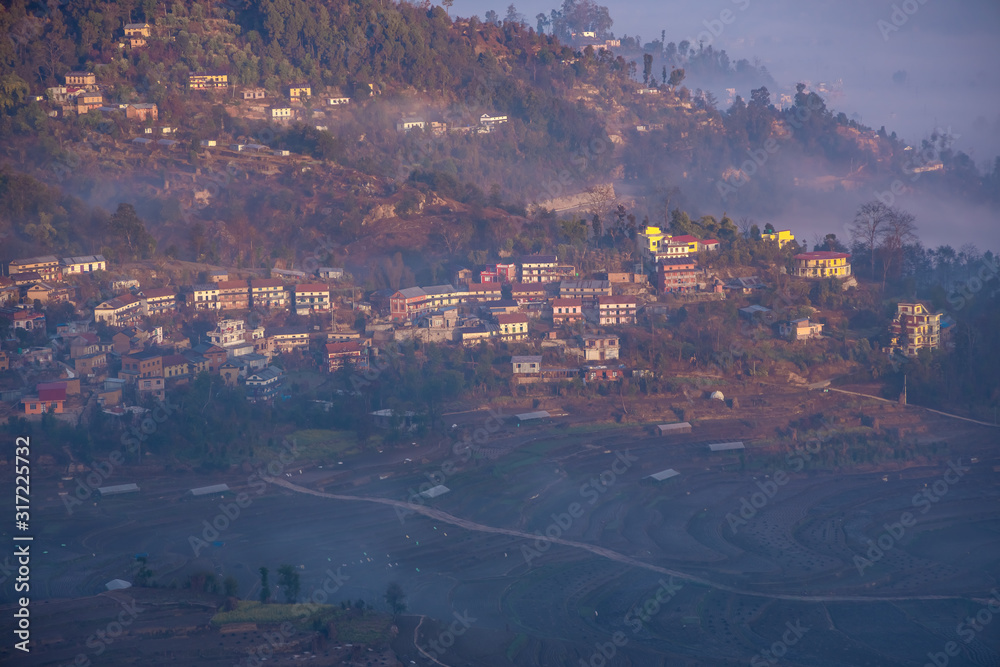 Traditional Nepali village in the mountains covered in fog during sunrise