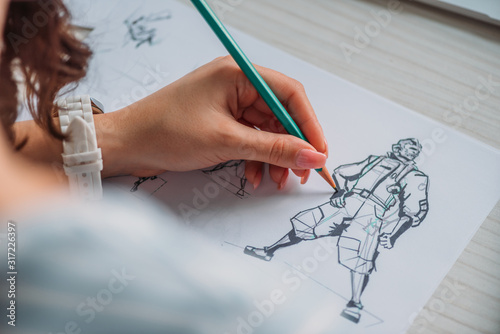 selective focus of illustrator drawing cartoon character on paper photo