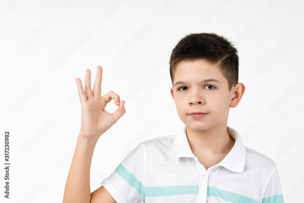 cute little boy in t-shirt making Ok gesture on white background. cute little boy in t-shirt making Ok gesture on white background.