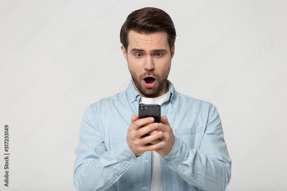 Head shot surprised young man looking at cellphones screen. Head shot surprised young man looking at cellphones screen.