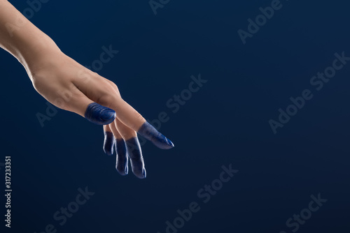 cropped view of female hand with painted fingers isolated on blue