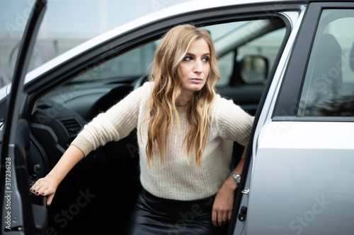 Beautiful woman sitting in car on a driver's seat © Rostyslav