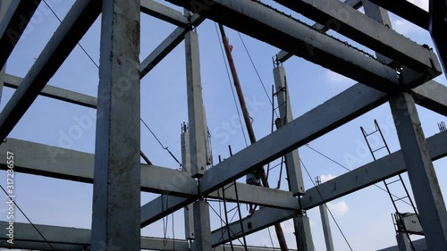 worker walking on high structure risk job . No safety tools . Heavy tripod crane  lift concrete  pillar