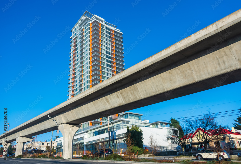 Skytrain lane in front of residential tower building Skytrain lane in front of residential tower building