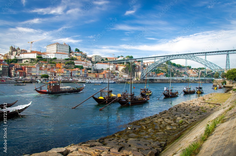 Portugal, city landscape Porto, wooden boats with wine port barrels on Douro river, panoramic view of the old town Porto,  The Eiffel Bridge view, Ponte Dom Luis, Porto in summer, colored houses