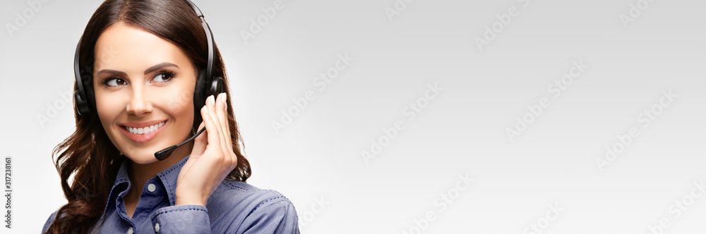 Call center customer support female phone operator or sales agent in headset, copy space for some text, advertising or slogan, against grey background Call center customer support female phone operator or sales agent in headset, copy space for some text, advertising or slogan, against grey background