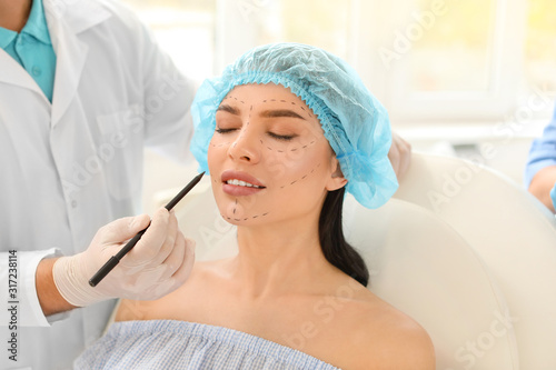 Plastic surgeon applying ma...