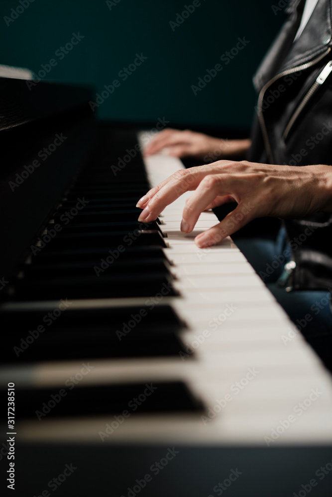 Fototapeta premium Woman hands playing keyboard at the studio