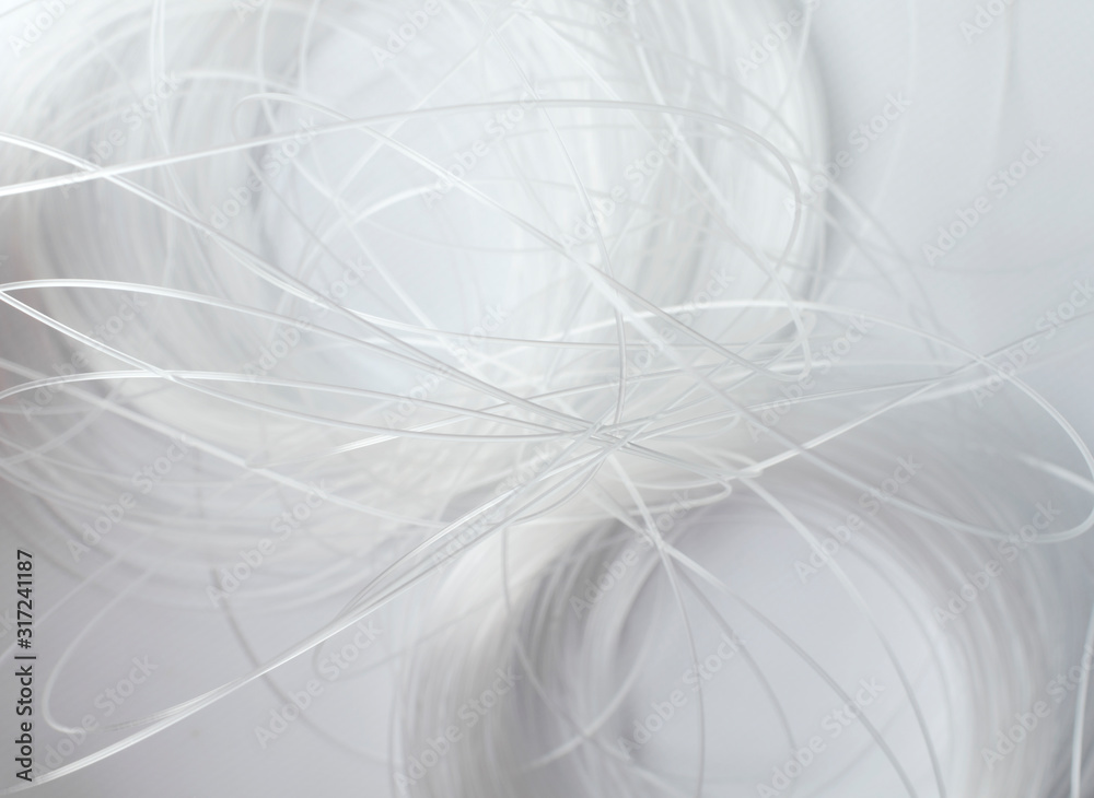 White matte fishing line on the white surface as a background White matte fishing line on the white surface as a background