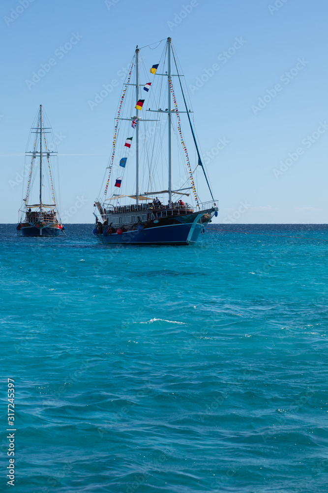 Two big ships with high masts sail in the Red Sea on sunny day