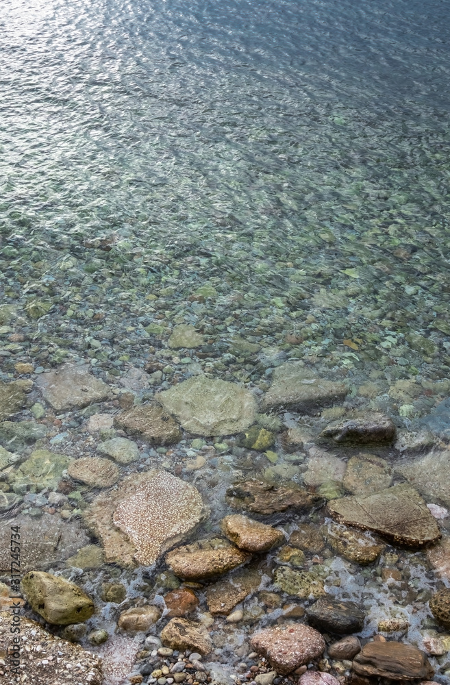 abstract sea background with water covering stones and pebbles. Vertical orientation abstract sea background with water covering stones and pebbles. Vertical orientation