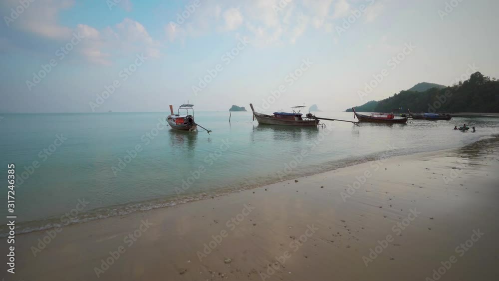 Long-tail boats floating at high tide on the paradise beach of Ko Yao Noi Island in the Adaman Sea, South Thailand Long-tail boats floating at high tide on the paradise beach of Ko Yao Noi Island in the Adaman Sea, South Thailand