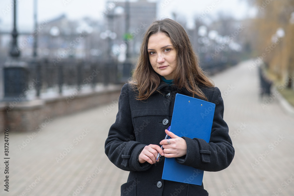 Portrait of a business woman outdoors. Cold cloudy weather. Portrait of a business woman outdoors. Cold cloudy weather.