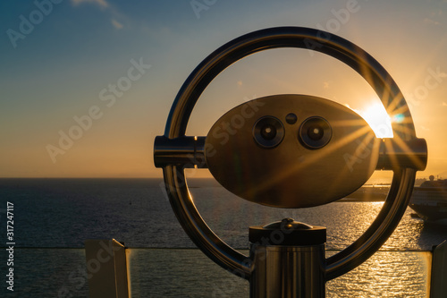 Binoculars on a cruise ship overlooking the sea at sunset photo