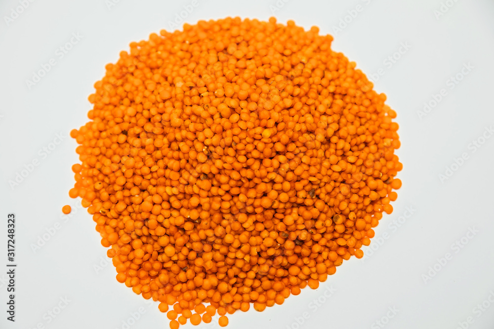 a handful of lentils poured in a slide on a white background a handful of lentils poured in a slide on a white background