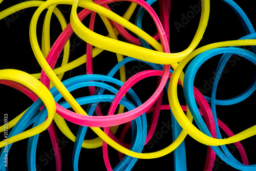 pile of colorful small rubber bands isolated on a black back ground