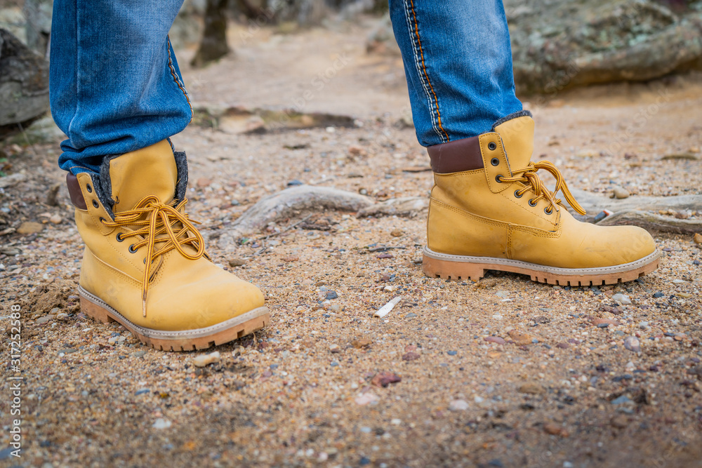 Pair of old yellow working boots on cliff