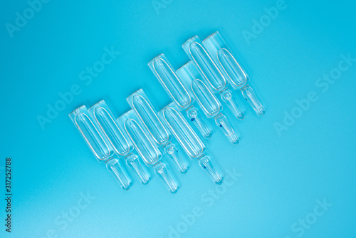 Ampules with a transparent preparation on a blue light background. Concept  drugs  injections  treatment  medicine.