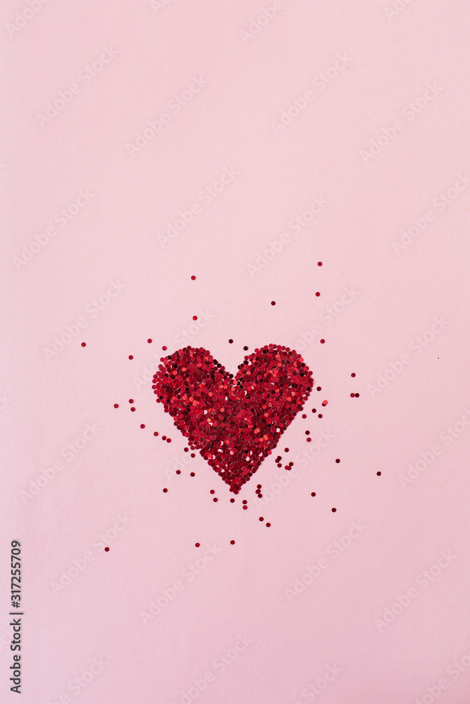 Heart symbol made of sparkles on pink background. Flatlay, top view Valentine's Day minimal holiday concept.