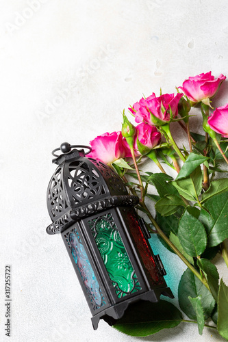 Arabic lantern with roze on a light background. Islamic holiday photo card. Festive background with copy space.