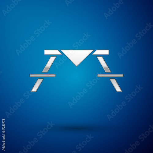 Silver Picnic table with benches on either side of the table icon isolated on blue background. Vector Illustration