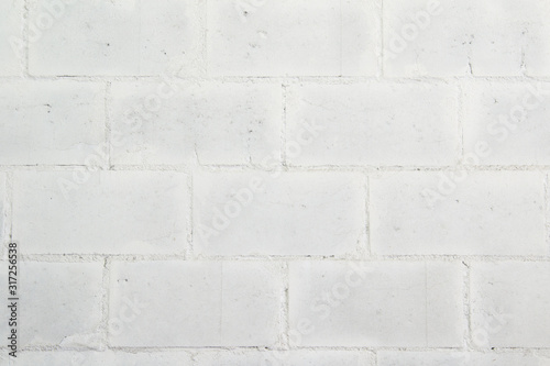 White wall made of large painted brick.