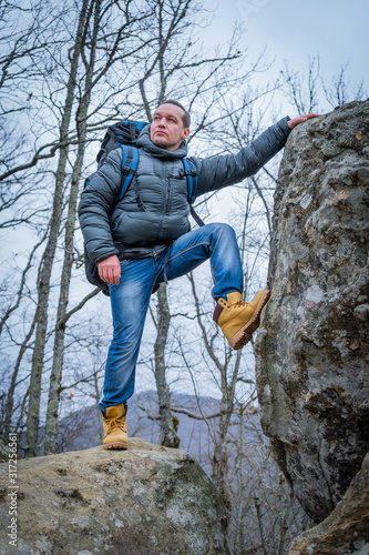 Tourist on the peak of high rocks. Sport and active life concept