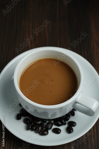 Black coffee in a white pitcher On an old wooden table
