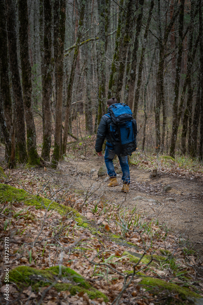 Man walking alone in deep autumn forest