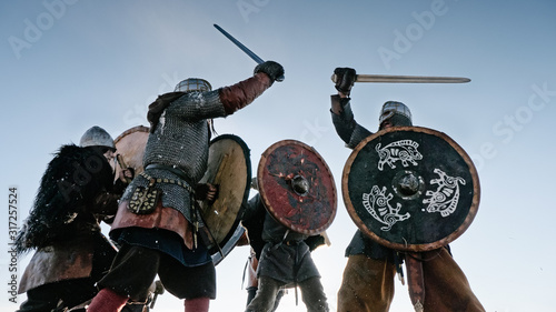 Warriors of vikings are fighting during attack at winter time.