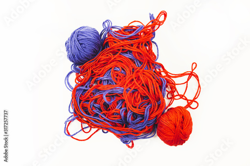 bright red and blue tangled threads on a white background
