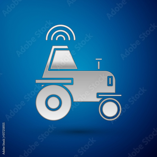 Silver Self driving wireless tractor on a smart farm icon isolated on blue background. Smart agriculture implement element. Vector Illustration