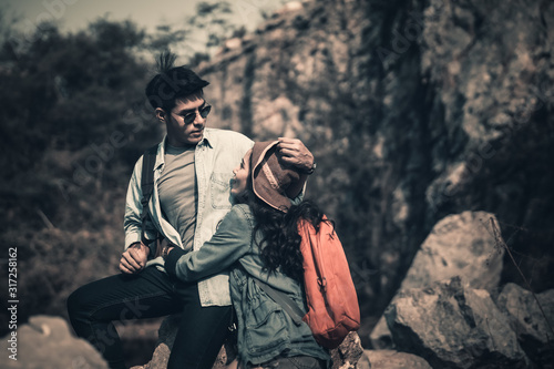backpackers tourists asian couple sitting on astone in natural forest photo