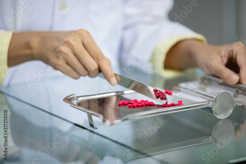 Pharmacist counting medicine on containers